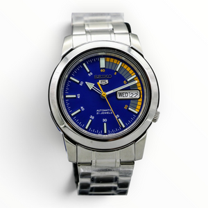 SUL EXTRAS Seiko 5 Speed Racer automatic watch with blue dial, yellow accents, and silver-tone stainless steel band.