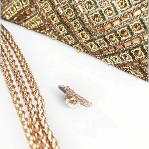 SUL EXTRAS Céleste evening bag featuring intricate geometric gold rhinestone embellishments and a gold chain strap.