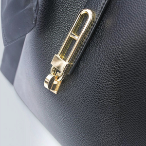 SUL EXTRAS Vivienne handbag featuring a gold-tone turn-lock closure on black grained synthetic material