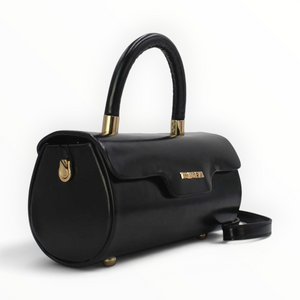 SUL EXTRAS black patent barrel handbag with gold-tone hardware, top handle, and magnetic flap closure.