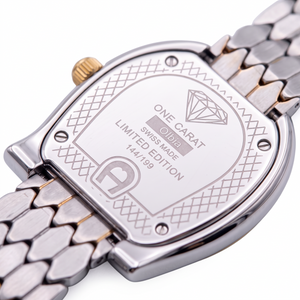 SUL EXTRAS Aigner Olbia watch caseback showing limited edition engraving, diamond symbol, and two-tone scale bracelet.