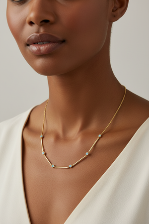 Gold necklace with blue gemstones on model