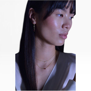 SUL EXTRAS gold plated layered necklace and pearl earrings set worn by a model with a red zirconia centerpiece