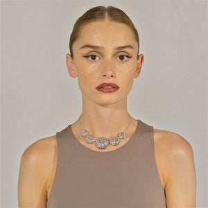 SUL EXTRAS Madras Rhodum necklace and earrings set featuring textured silver-tone spheres on a model