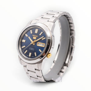SUL EXTRAS Seiko 5 automatic watch with midnight blue sunburst dial, gold accents, and stainless steel bracelet.