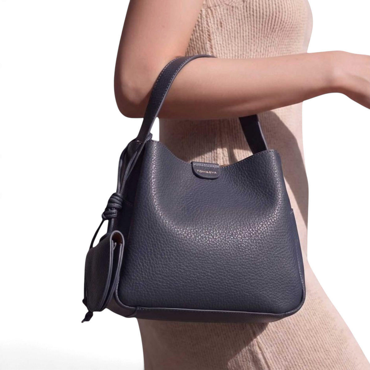 SUL EXTRAS Tom & Eva Noémie bucket bag in dark grey grained synthetic leather with knotted detail and key charm.