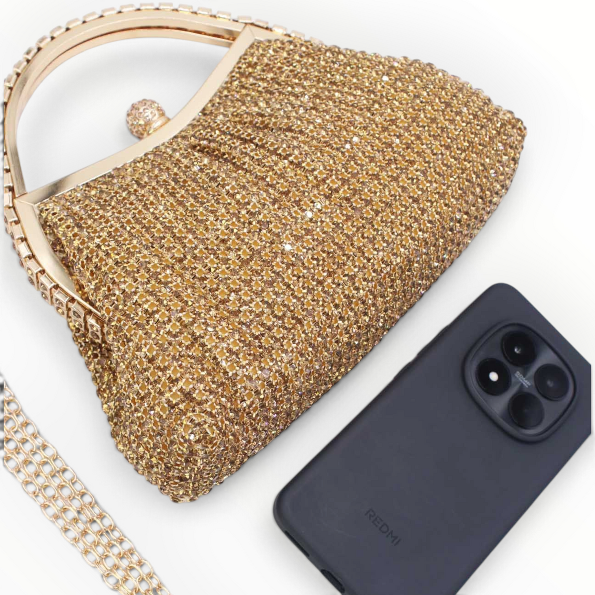 SUL EXTRAS Estelle evening bag in gold with rhinestone embellishments, arched handle, and detachable chain strap.