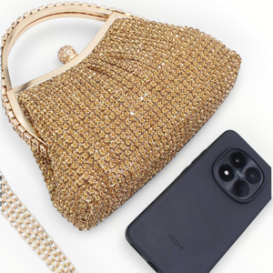 SUL EXTRAS Estelle evening bag in gold with rhinestone embellishments, arched handle, and detachable chain strap.