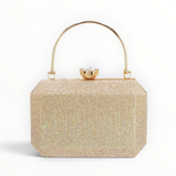 SUL EXTRAS Odette evening bag in gold with shimmering rhinestone detailing, arched handle, and faceted floral clasp.