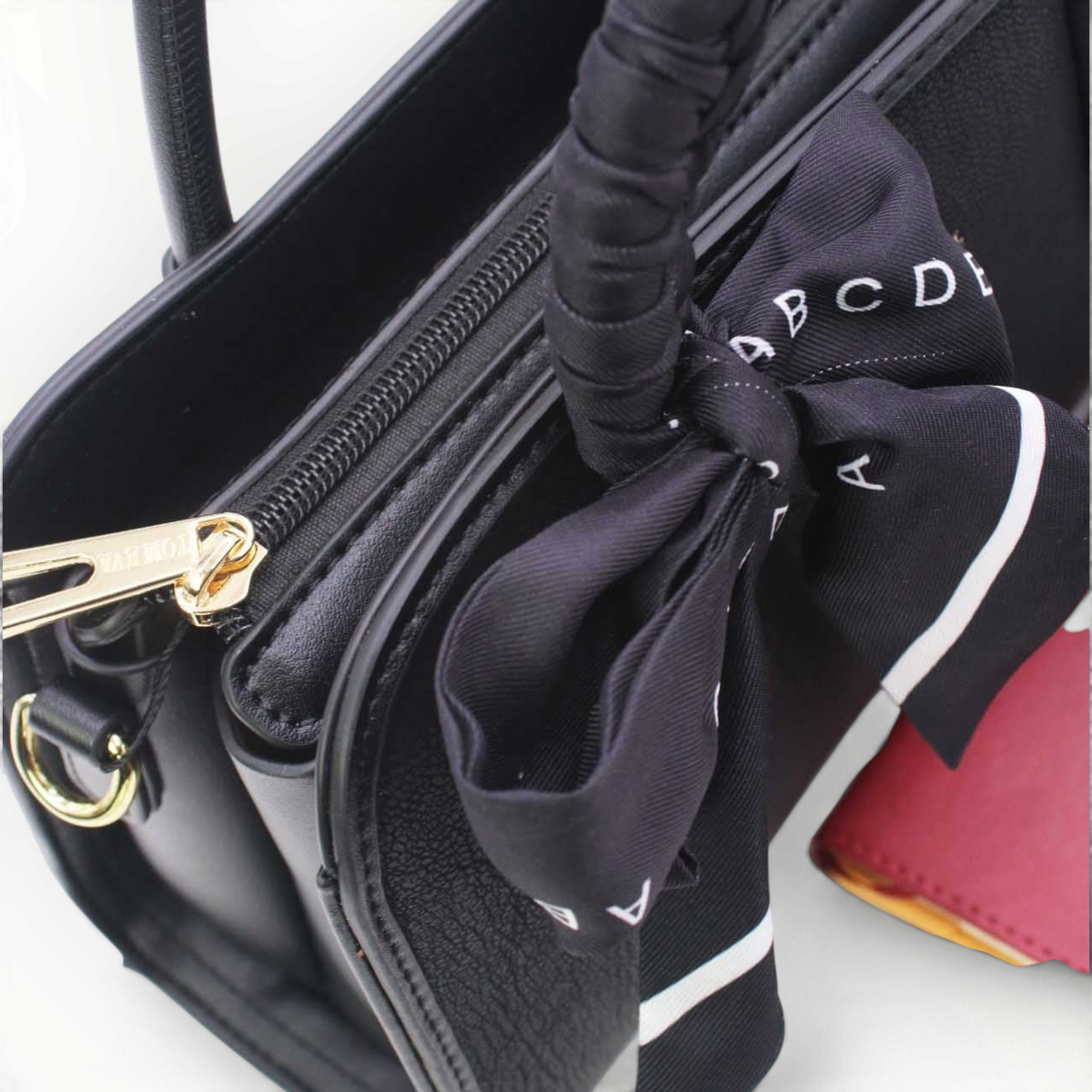 SUL EXTRAS Juliette handbag in black synthetic leather with gold hardware, zip closure, and decorative scarf detail.
