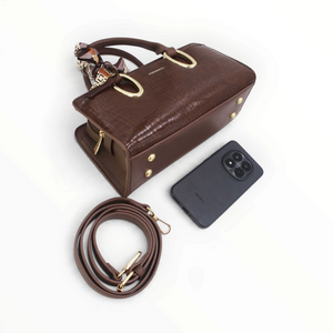 SUL EXTRAS Tom & Eva Amélie brown croc-effect handbag with gold hardware, decorative scarf, and shoulder strap.