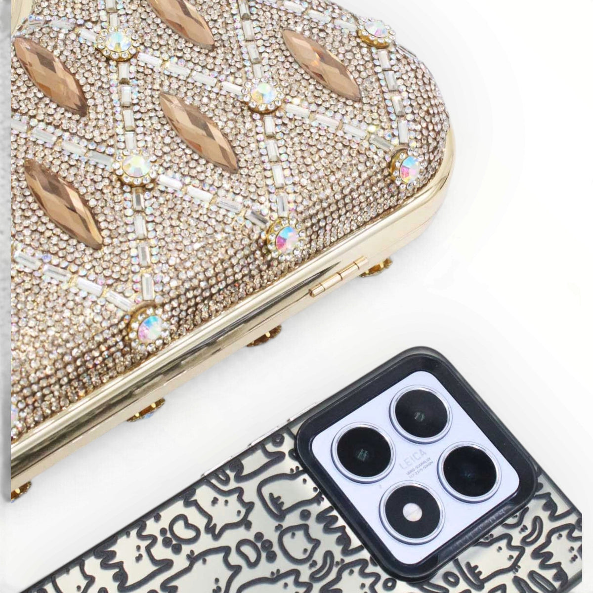 SUL EXTRAS Aurelia evening bag featuring gold rhinestone latticework and faceted accents next to a smartphone