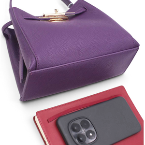 SUL EXTRAS Adèle purple grained synthetic shoulder bag with gold-tone hardware and belt detail next to a red notebook.
