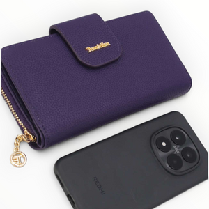 SUL EXTRAS Tom & Eva purple pebbled leather-effect wallet with gold-tone hardware and snap closure next to a phone