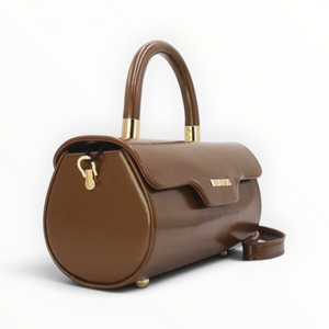 SUL EXTRAS Tom & Eva brown patent barrel handbag with gold-tone hardware, top handle, and magnetic flap closure.