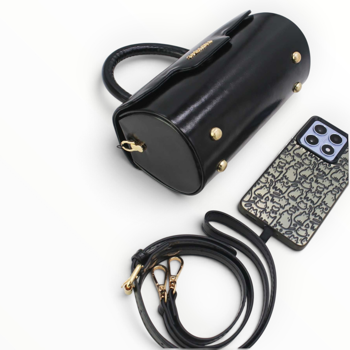 SUL EXTRAS Tom & Eva black patent barrel handbag with gold hardware, top handle, and detachable shoulder strap.