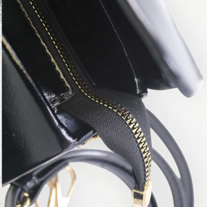 SUL EXTRAS Tom & Eva Colette handbag in black patent synthetic leather with gold-tone zipper and top handle detail