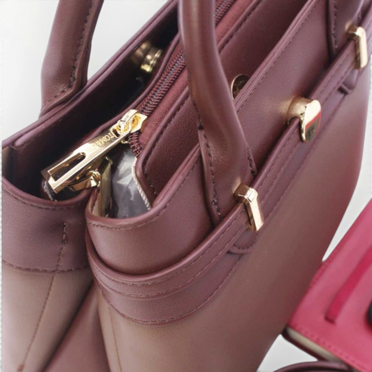 SUL EXTRAS Tom & Eva Élise medium handbag in burgundy synthetic leather with gold-tone hardware and belt detail.