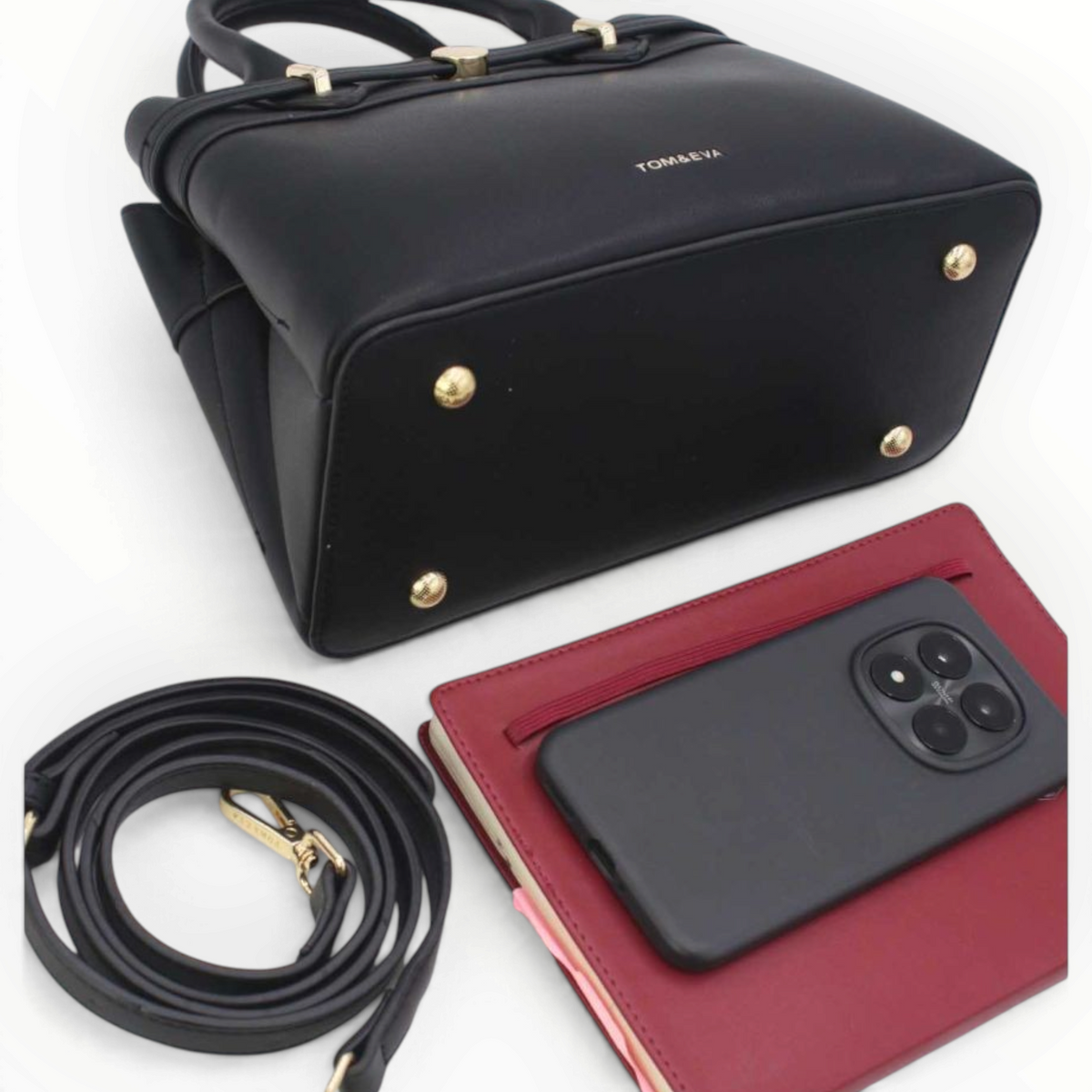 SUL EXTRAS Tom & Eva black structured handbag with gold feet, detachable strap, and accessories on white background