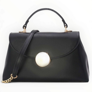 SUL EXTRAS Tom & Eva black structured handbag with a gold-tone circular accent, top handle, and shoulder strap.