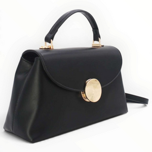 SUL EXTRAS Tom & Eva black structured handbag with a gold-tone circular clasp, top handle, and magnetic flap closure.