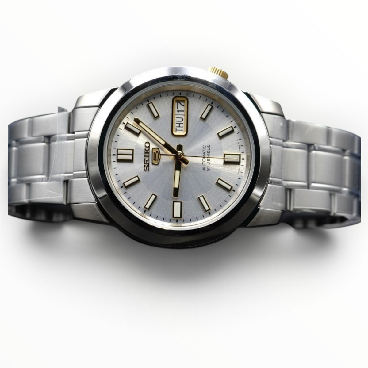 SUL EXTRAS Seiko 5 automatic watch with a silver dial, stainless steel bracelet, and gold-tone hands and markers.
