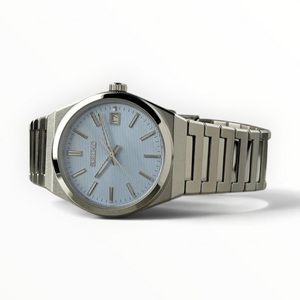SUL EXTRAS Seiko Classic men's watch with a light blue textured dial, silver stainless steel case, and bracelet.
