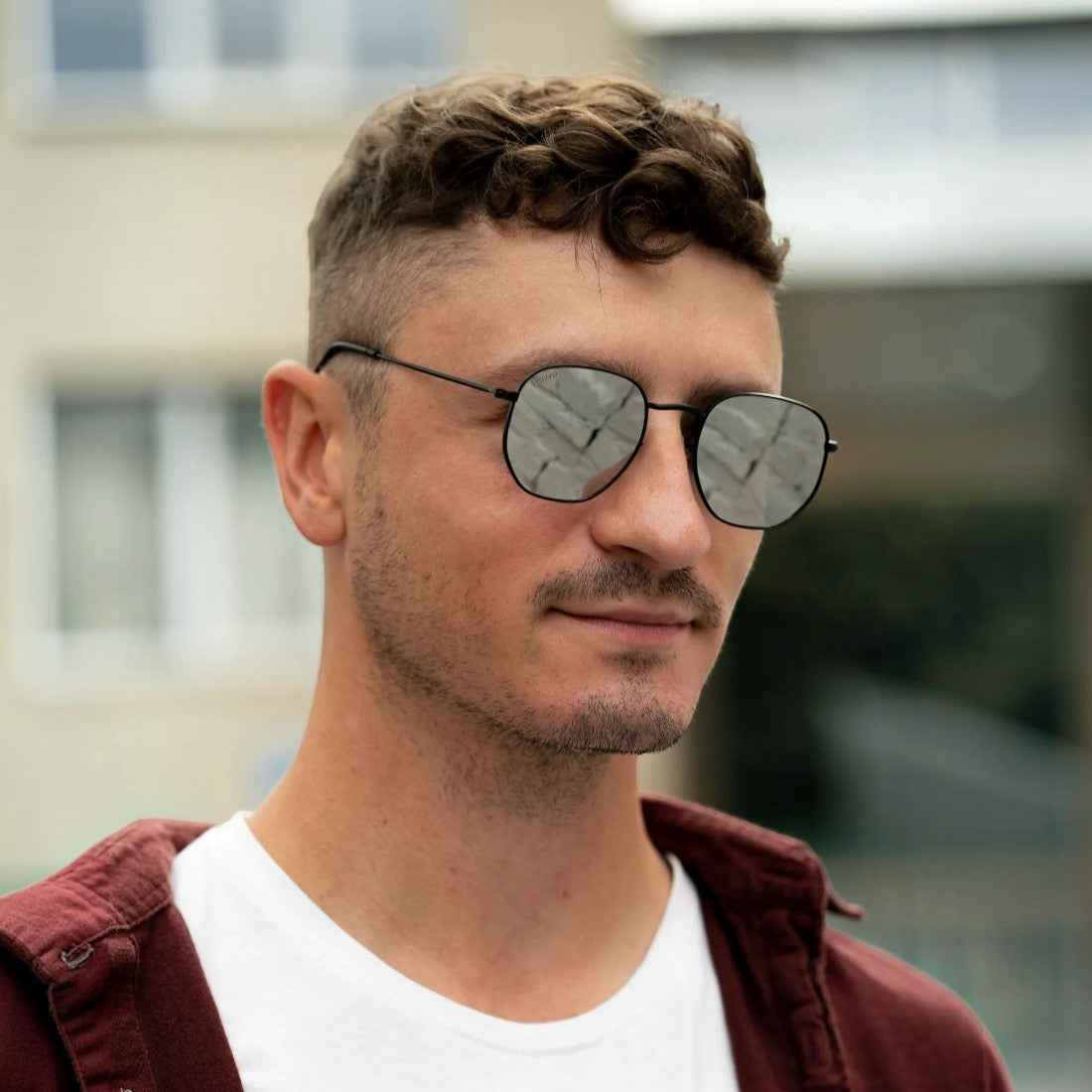 SUL EXTRAS Eternally minimalist geometric sunglasses with reflective lenses worn by a man in a maroon shirt