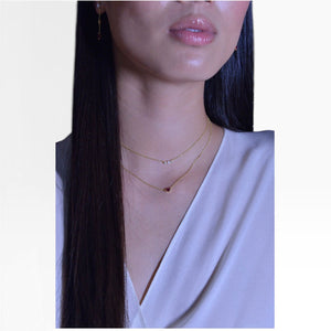 SUL EXTRAS gold plated layered necklace with pearls and red zirconia worn by a woman