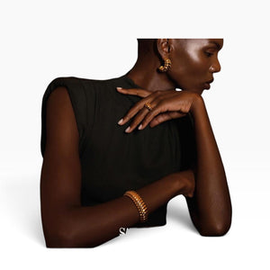 SUL EXTRAS Grace Set featuring gold ribbed hoop earrings and a matching sculptural ring worn by a model.