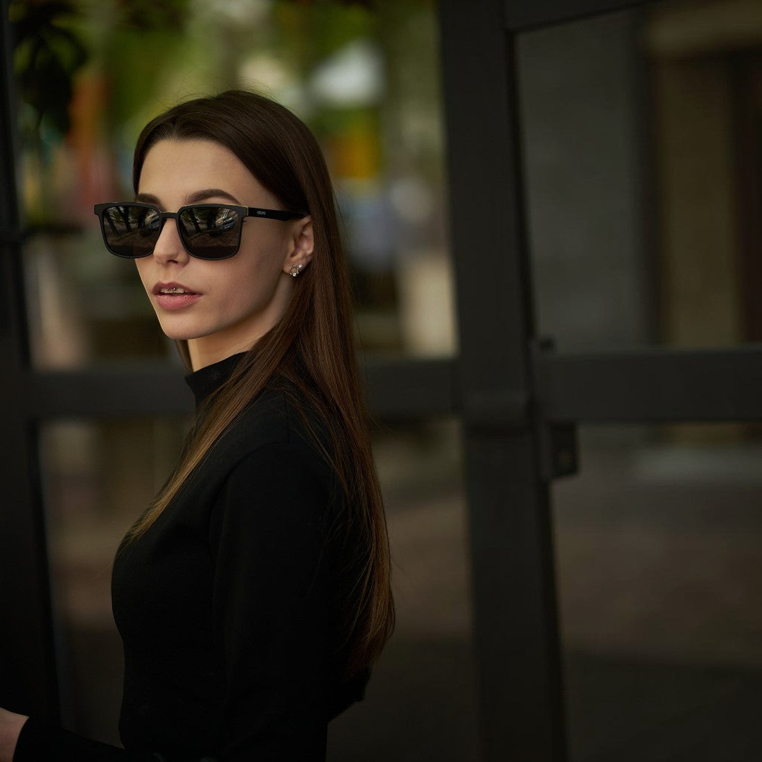 Woman wearing SUL EXTRAS Leo polarized sunglasses with black frames and scratch-resistant lenses